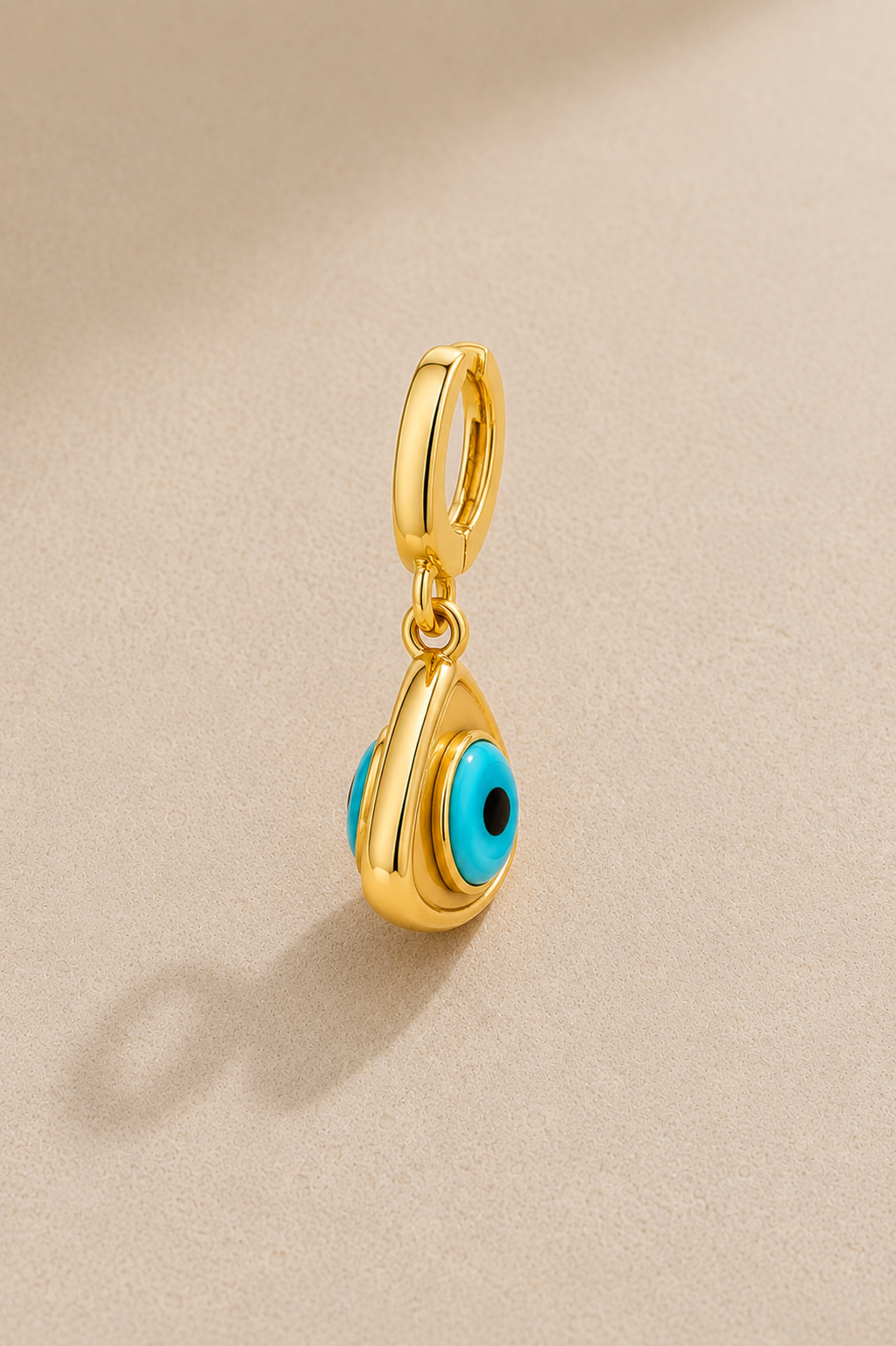 Side view of gold evil eye hook charm showing double-sided turquoise eye detail