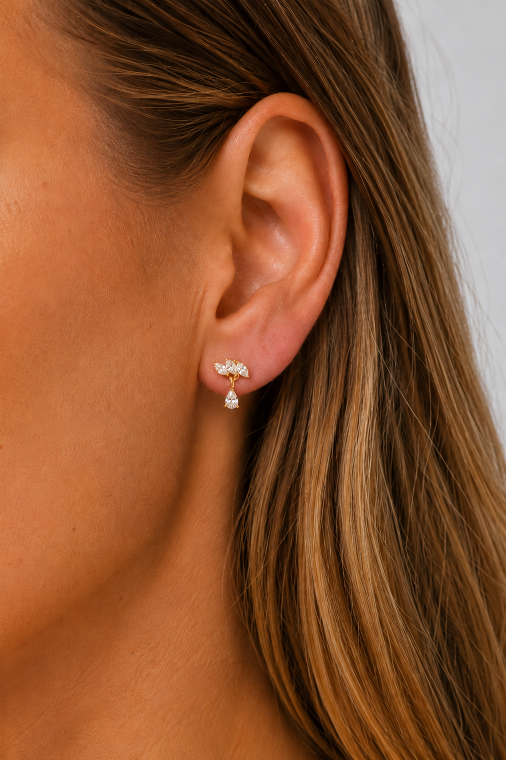 Fleur Gold Stud Earring worn on ear with delicate white CZ sparkle