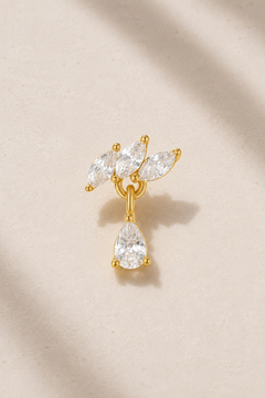 Floral-inspired gold stud earring with white CZ stones on neutral stone background