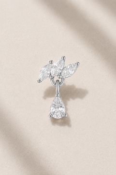 Floral-inspired silver stud earring with white CZ stones on neutral stone background