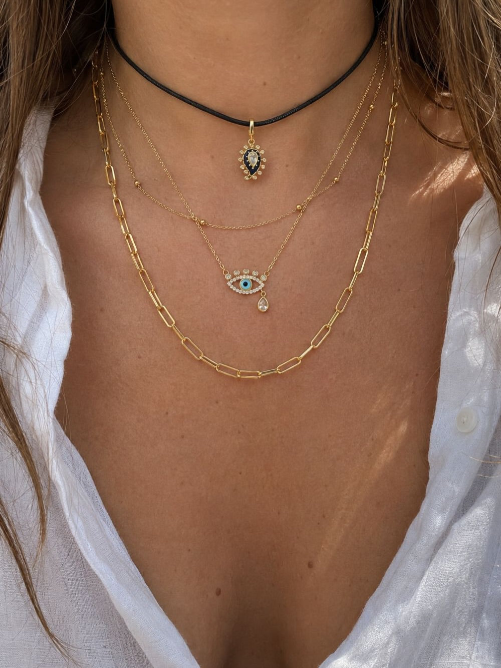 Layered gold necklace look by Galleria Armadoro with evil eye charms, black cord necklace and Large Link Gold Chain worn at 45 cm.
