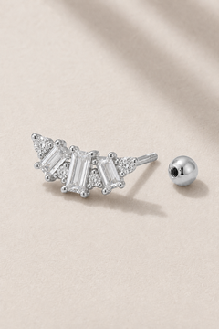 Silver Art Deco ball screw piercing stud with white CZ stones on neutral stone background