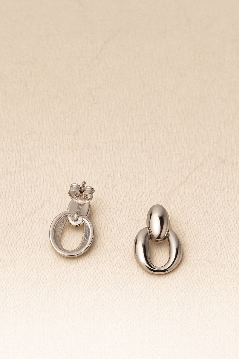 Pair of silver hoop earrings on a beige background