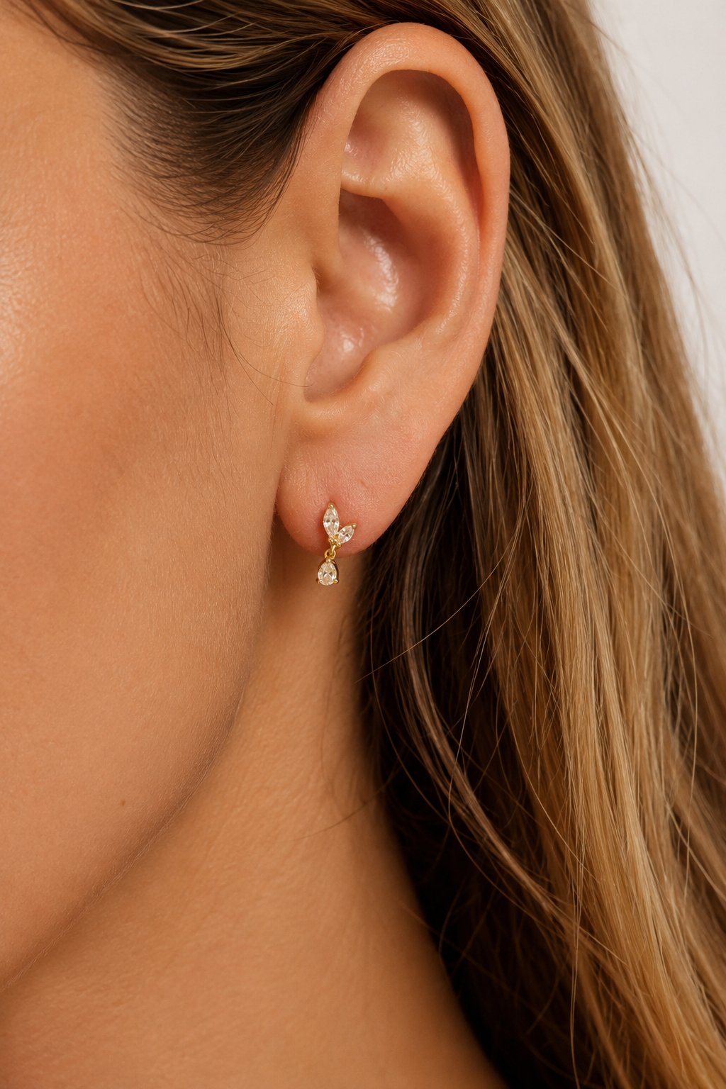 Papillon Gold Stud Earring worn on ear with delicate white CZ sparkle
