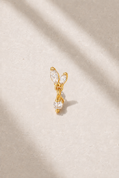 Butterfly-inspired gold stud earring with marquise stones on neutral stone background