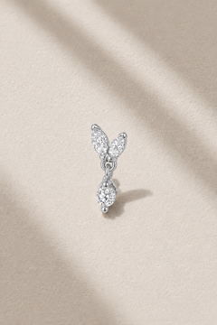 Butterfly-inspired silver stud earring with marquise stones on neutral stone background