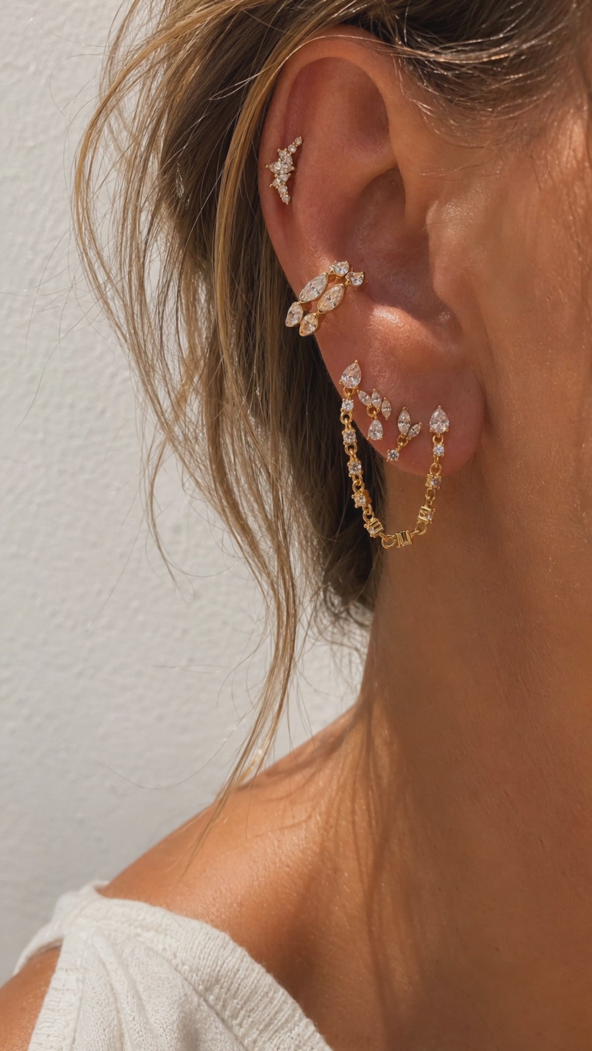 Layered gold ear stack styled by Galleria Armadoro with marquise earrings, linked chain details and sculptural upper-ear placements.