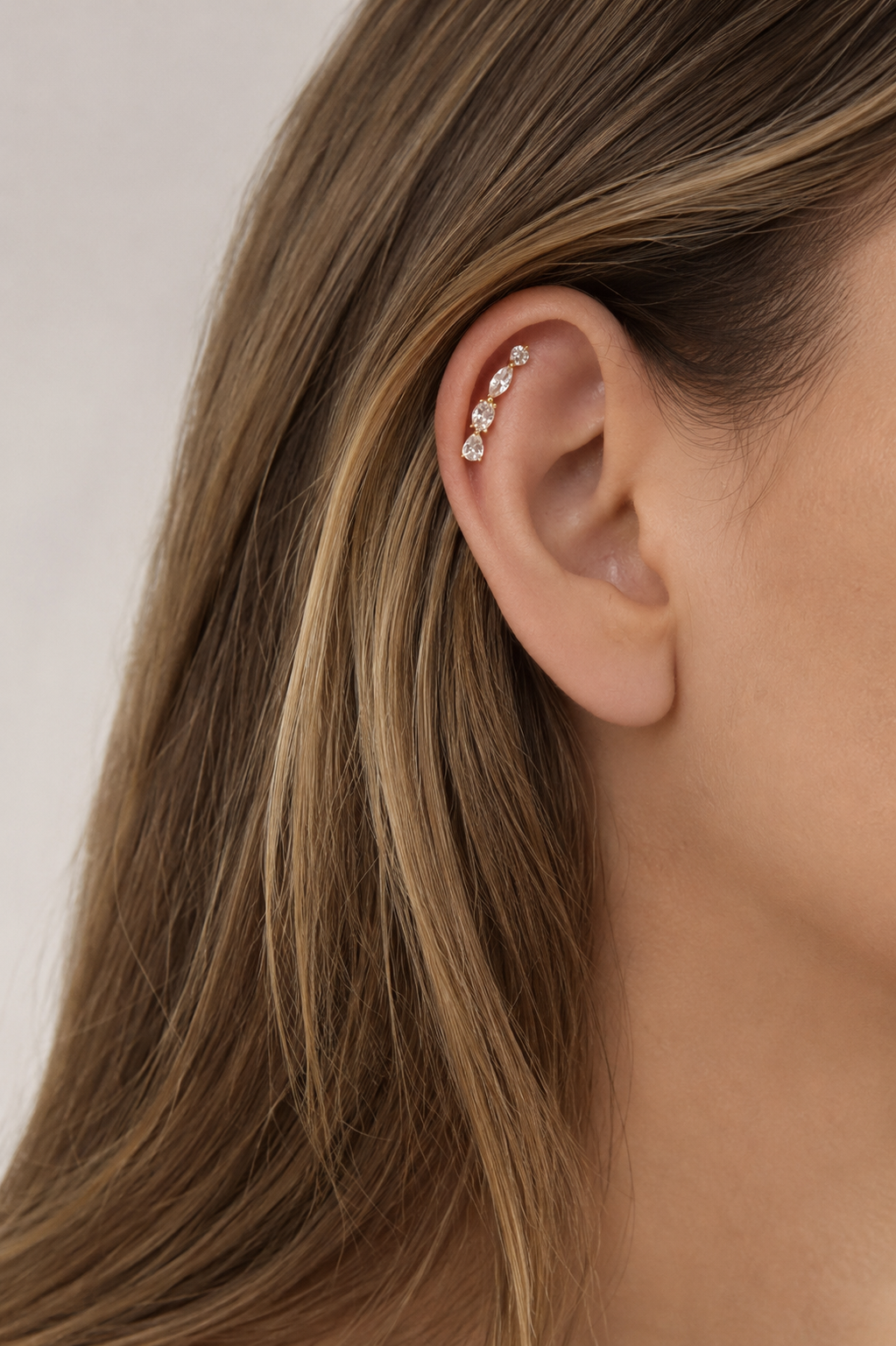 Close-up detail of Riviera Gold Ear Climber with pear, oval, marquise and round CZ stones