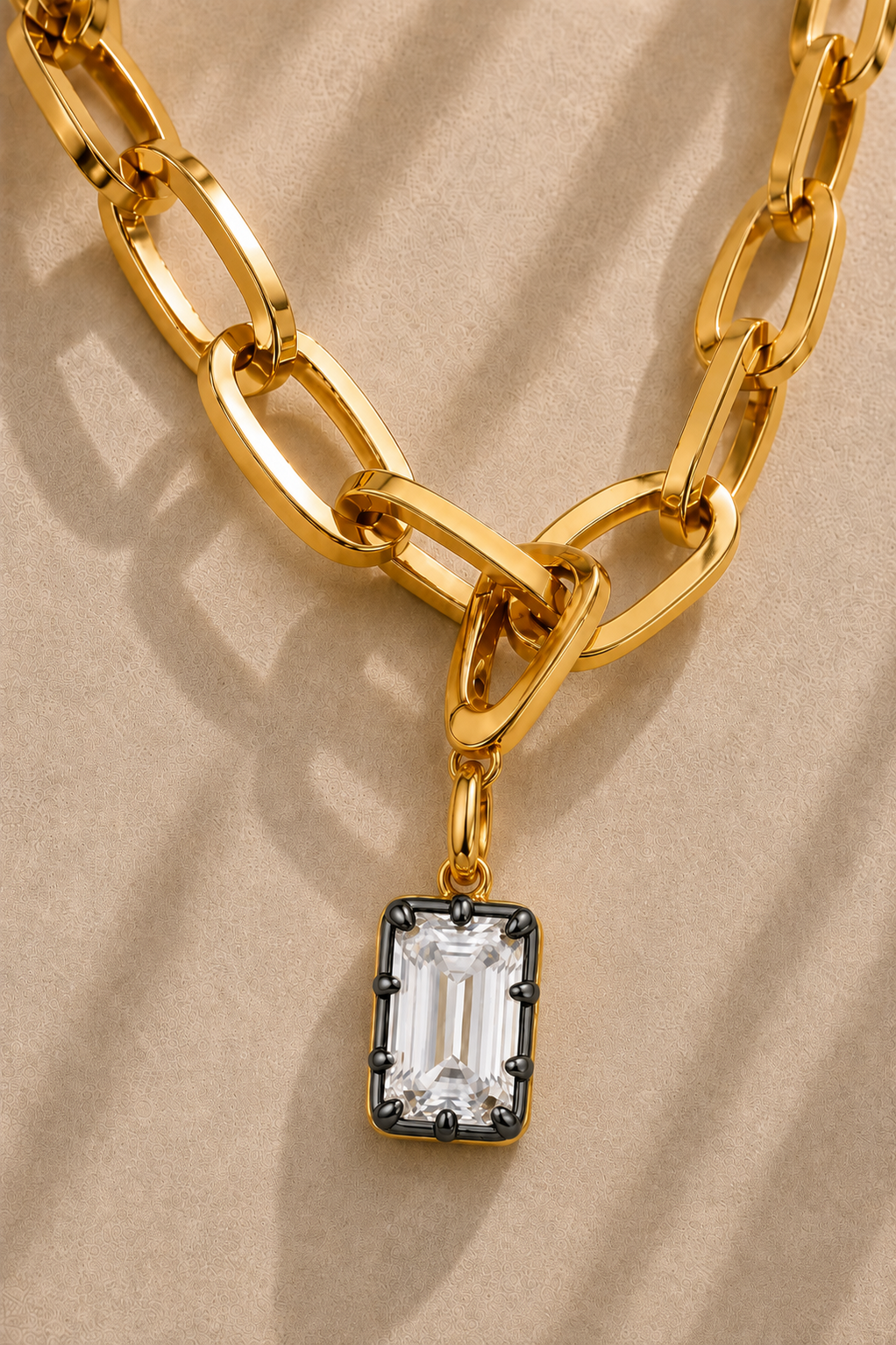 Close-up of the Vittoria Emerald Cut black rhodium and gold hook charm on the Cara gold plated chain