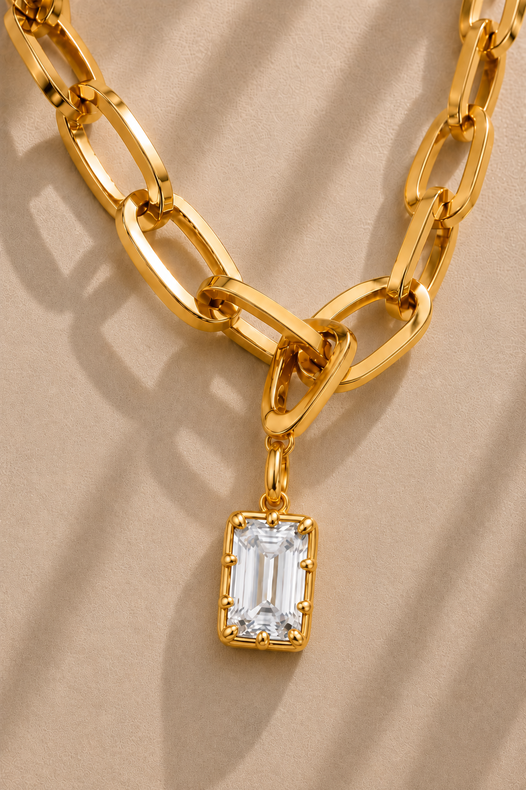 Close-up of the Vittoria Emerald Cut gold hook charm on the Cara gold plated chain