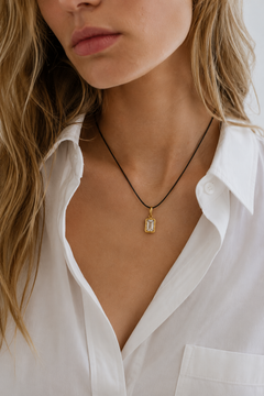 Model wearing adjustable black cord necklace with Vittoria emerald-cut 24ct gold plated hook charm