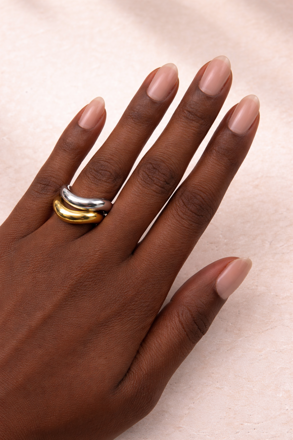 Model wearing the Kyma Ring Duo with mixed metal wave rings stacked on fingers
