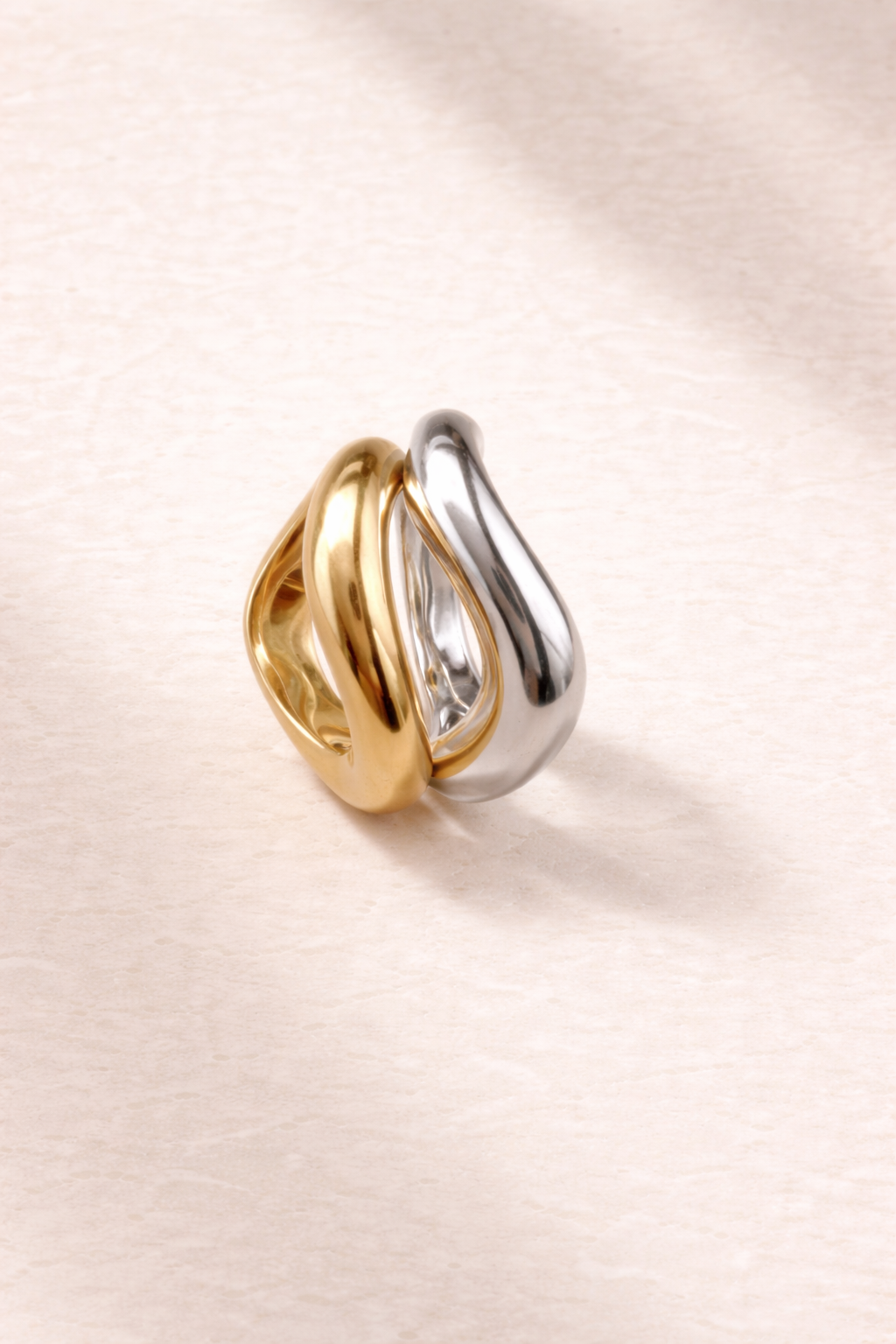 Gold vermeil and sterling silver Kyma wave rings styled side by side on a clean background