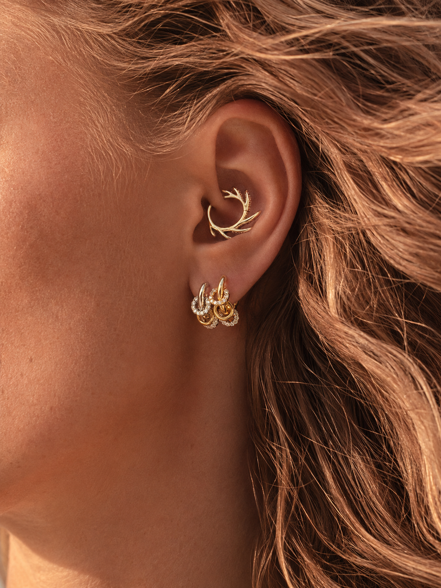 Mixed-metal ear stack styled by Galleria Armadoro with a sculptural gold Ellara daith earring and gold and silver Yasmin lobe earrings.
